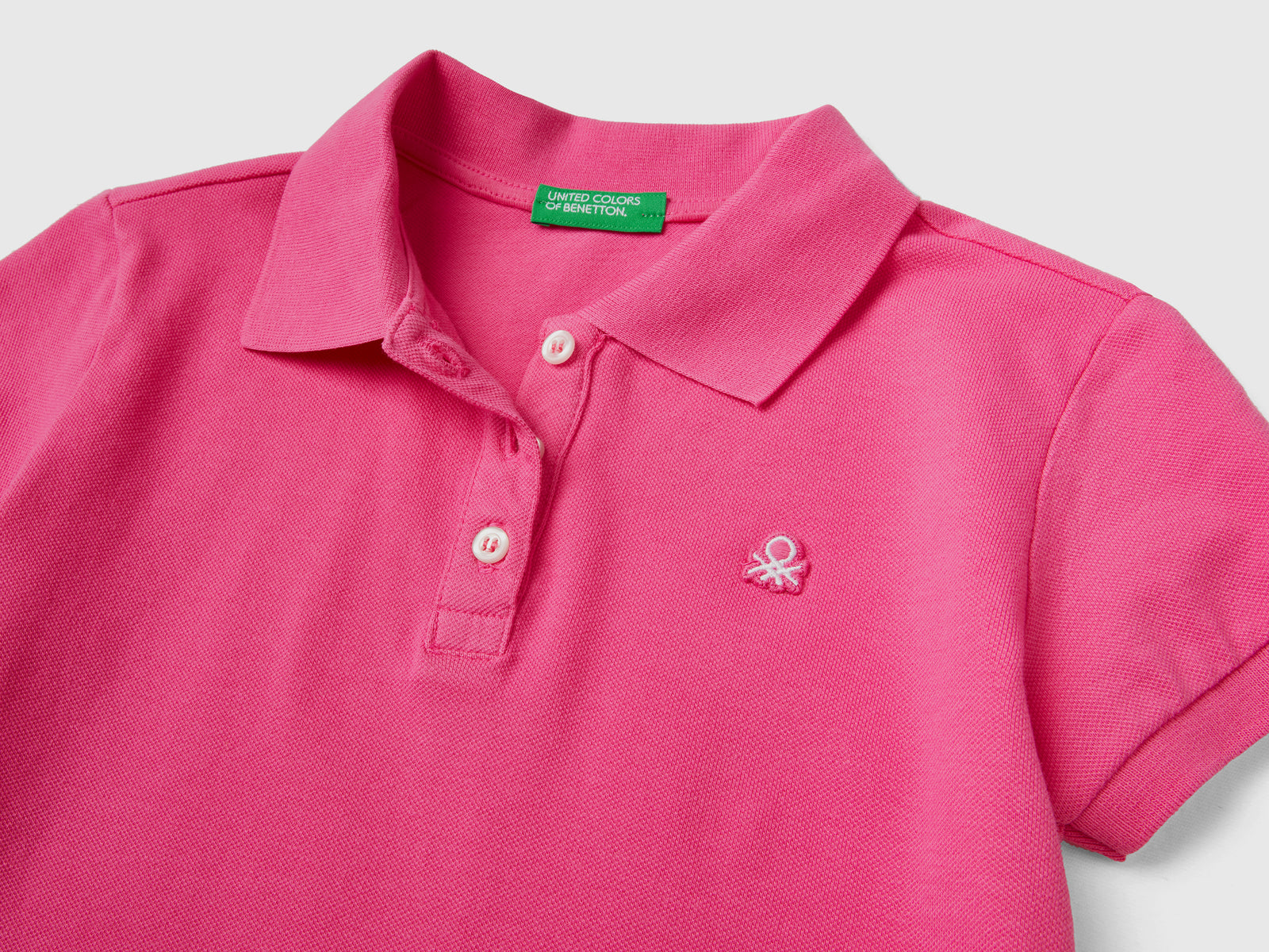 Polo a manica corta in piquet di cotone elasticizzato da bambina fucsia 2 | Benetton Outlet