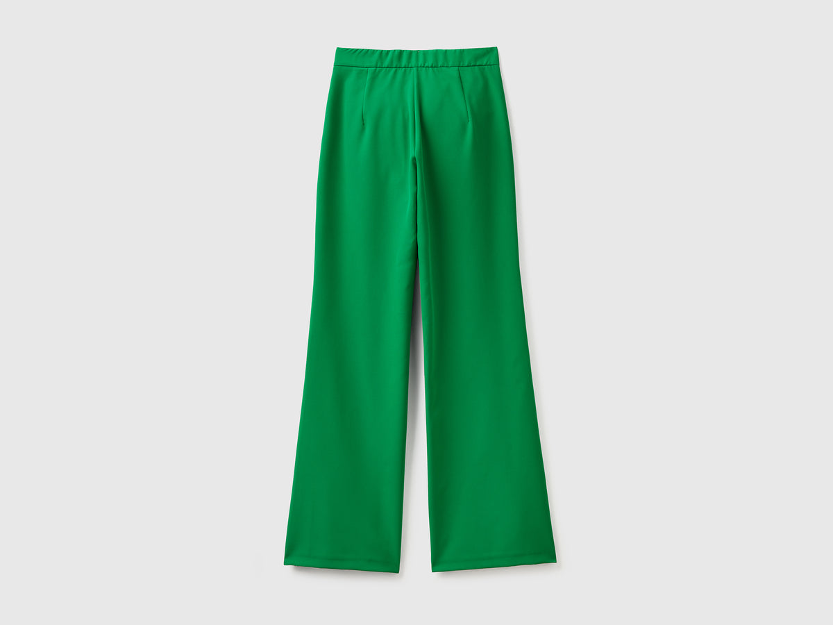 Pantaloni lunghi in tessuto elasticizzato con gamba svasata sul fondo
