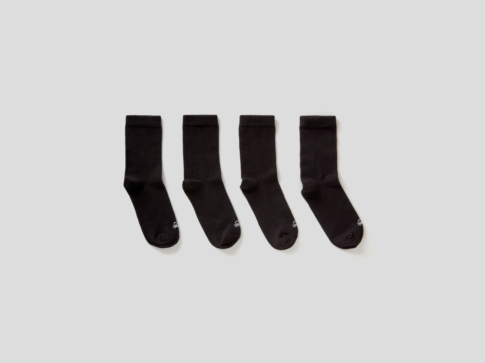 Quattro paia di calze in cotone  stretch da bambino nero | Benetton Outlet