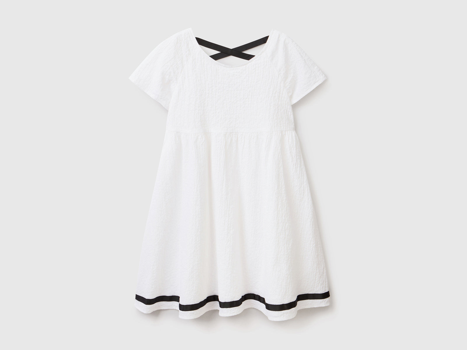 Abito svasato a manica corta in cotone elasticizzato dal peso medio da bambina bianco | Benetton Outlet