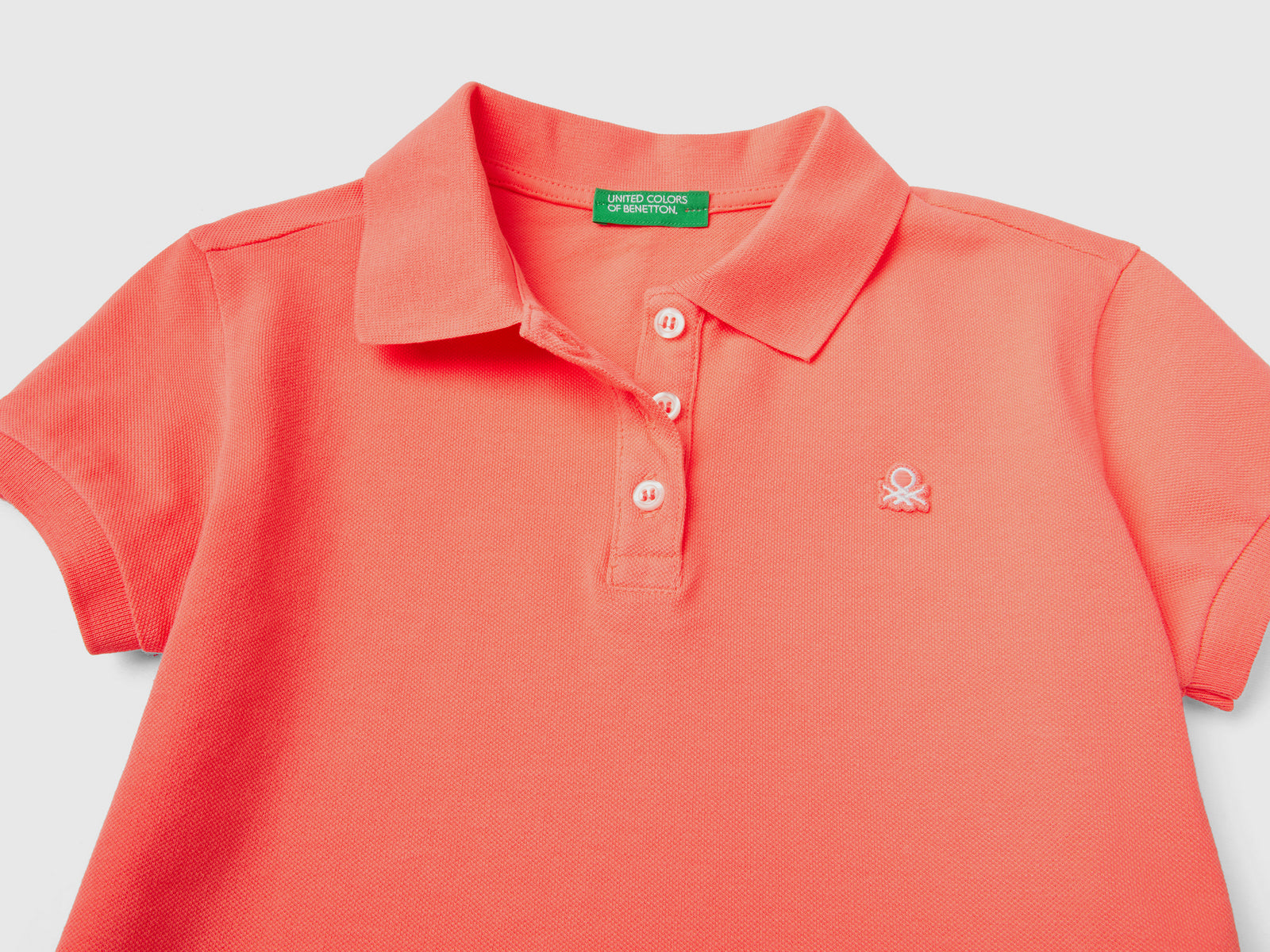 Polo a manica corta in piquet di cotone elasticizzato da bambina arancione 2 | Benetton Outlet