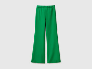 Pantaloni lunghi in tessuto elasticizzato con gamba svasata sul fondo